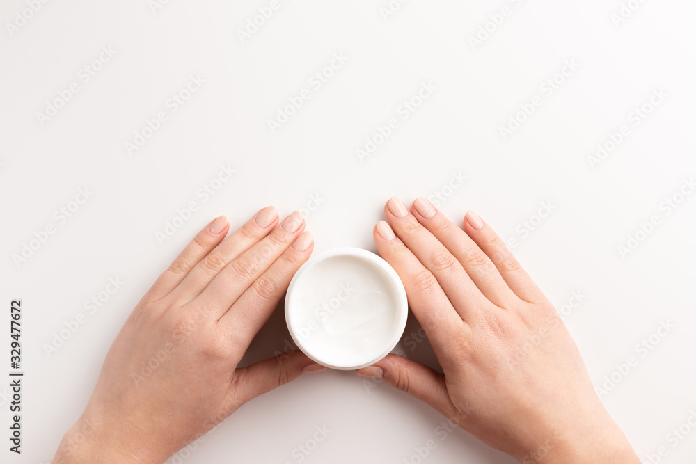 Care cosmetic concept. Female hands holding container of cosmetic cream, isolated on white background. Flat lay, top view, copy space. Care cosmetic concept. Female hands holding container of cosmetic cream, isolated on white background. Flat lay, top view, copy space.
