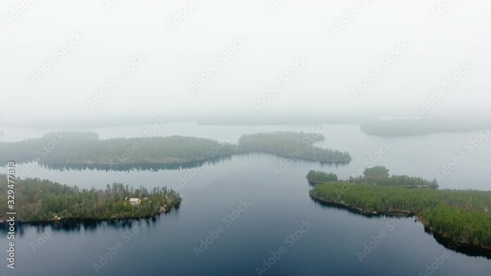 Aerial shot of small islands with dense forest, a calm lake and a small settlement (Willard Lake, Ontario, Canada) Aerial shot of small islands with dense forest, a calm lake and a small settlement (Willard Lake, Ontario, Canada)