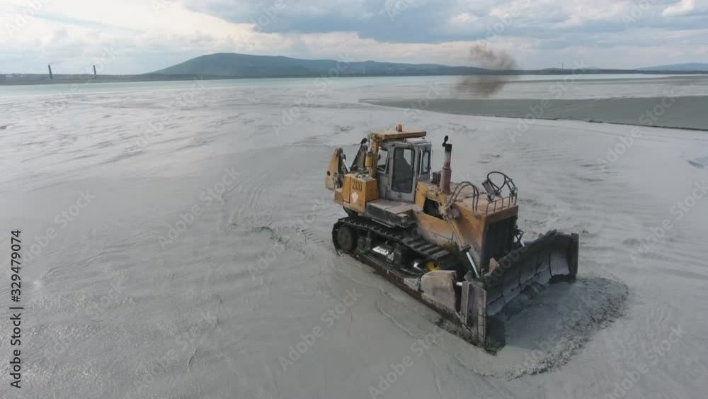 yellow bulldozer clears the embankment,aerial wiev yellow bulldozer clears the embankment,aerial wiev
