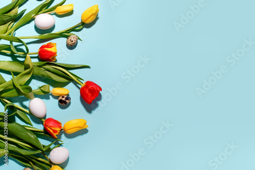 Springtime season greeting card - happy easter concept - multicolored tulips and eggs on bright blue background, copy space, sale, discount, celebrate banner, hard shadow, trend