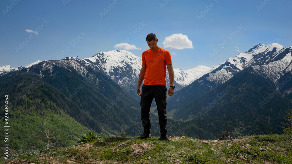 The guy in the orange shirt in the background of mountains