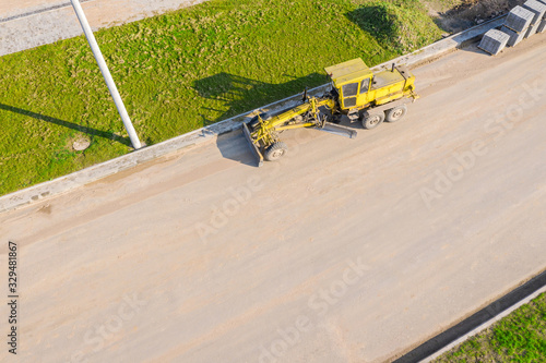 road grader standing at road construction site after use. aerial view