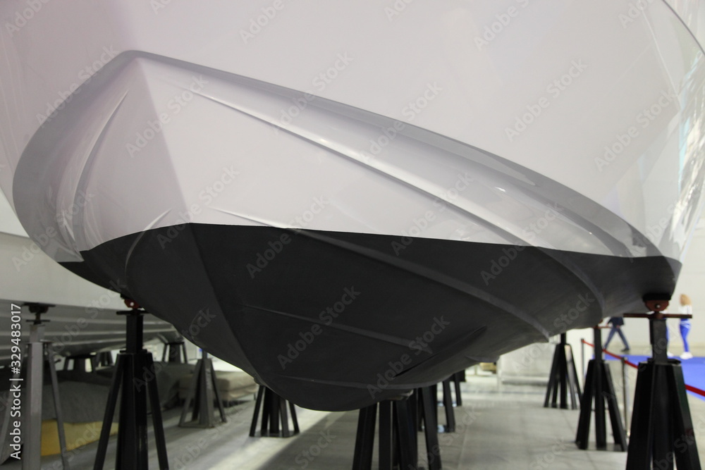 Antifouling protective coating on the bottom waterline of the motor boat on the slipway, ship maintenance service