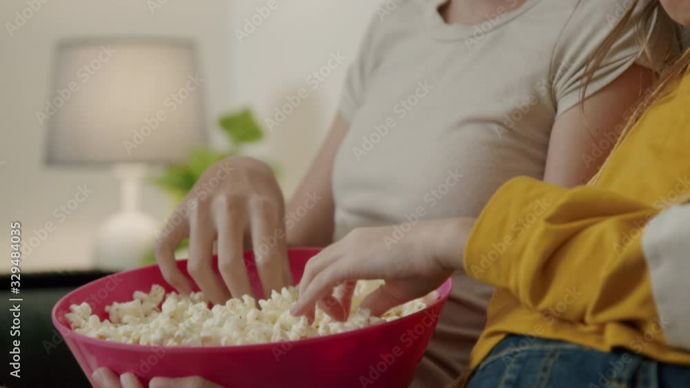 Sister Girls Watching a Movie and Eating Popcorn in Couch Sister Girls Watching a Movie and Eating Popcorn in Couch