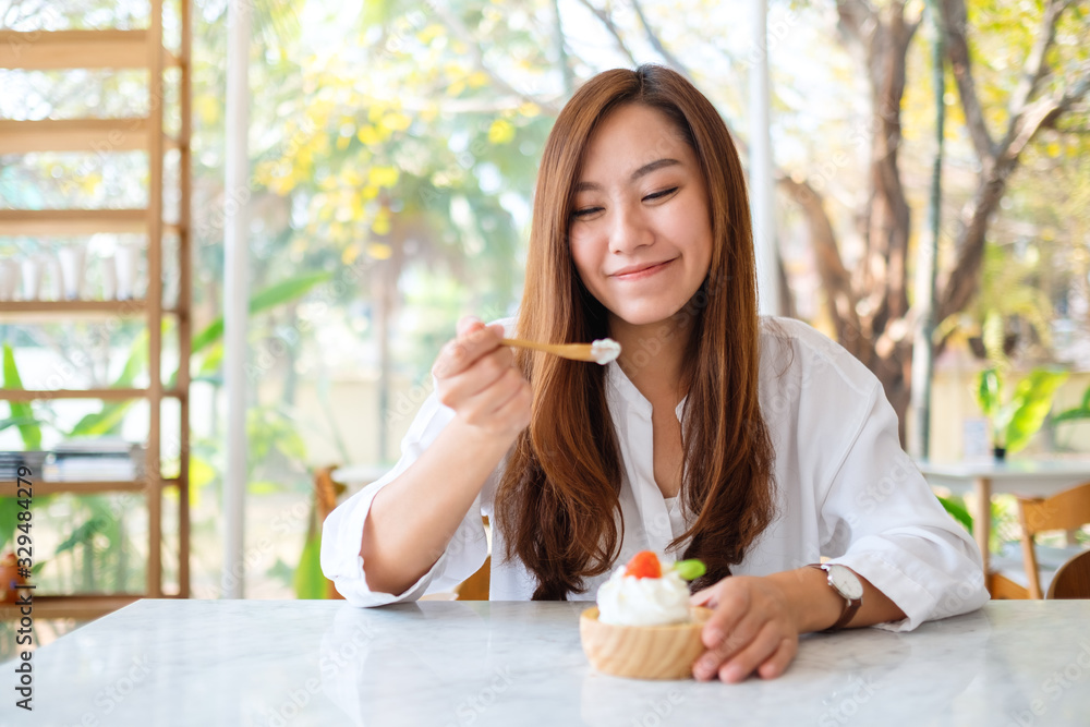 Closeup image of a beautiful asian woman enjoy eating an ice cream in restaurant
