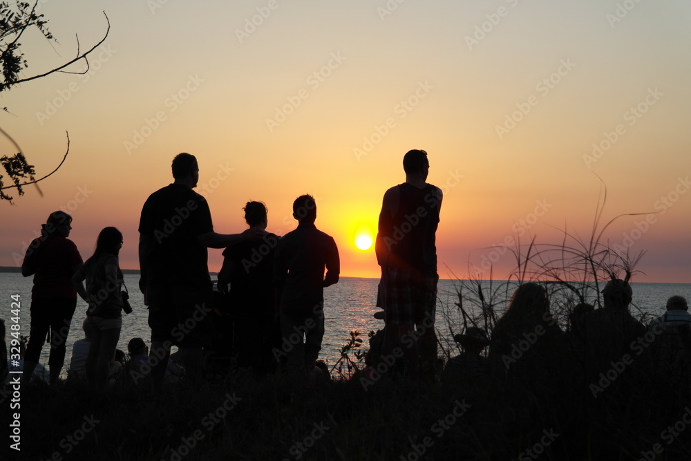 Silhouette of people on beach at Sunrise or Sunset.