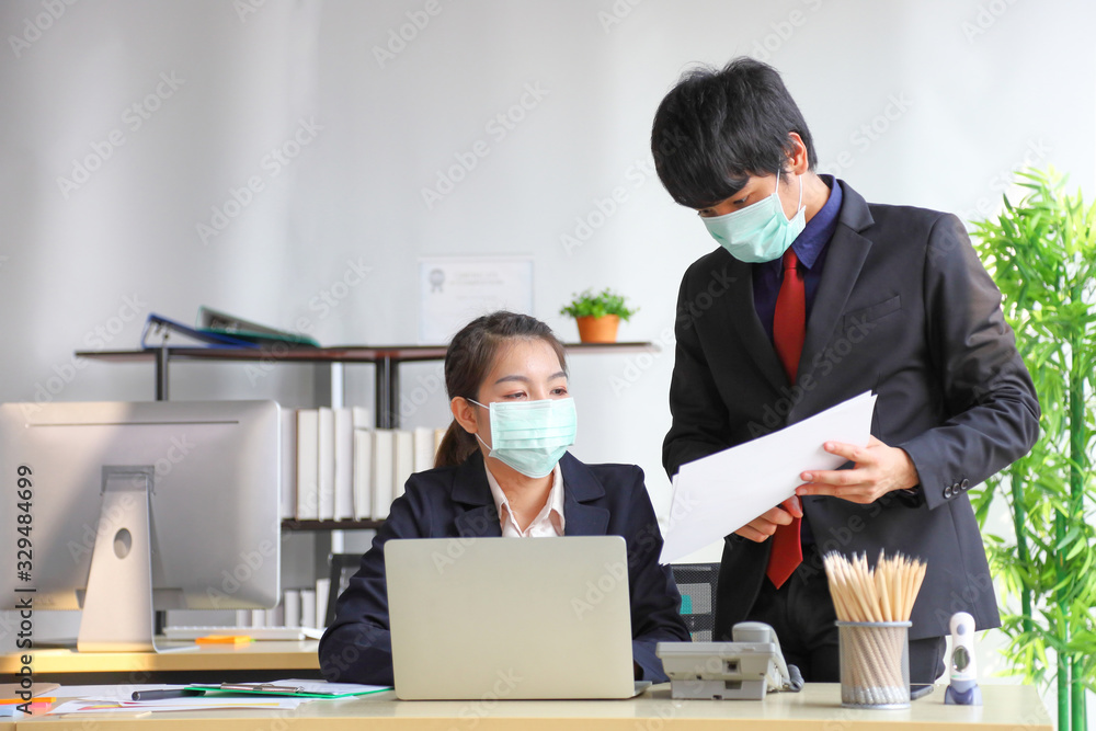 Manager and secretary are working in business office while wearing medical face mask for protecting and preventing the infection of corona virus or covid-19 Manager and secretary are working in business office while wearing medical face mask for protecting and preventing the infection of corona virus or covid-19