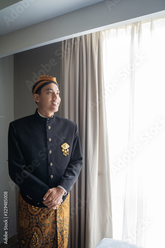 Asian man wearing traditional clothes,beskap is traditional heritage clothes from Java,Indonesia photo