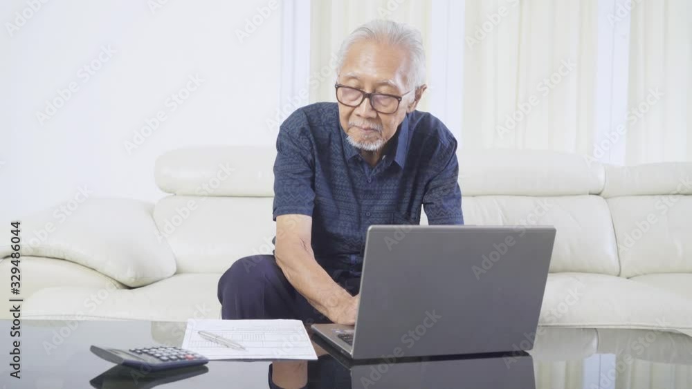 Old man using a laptop to filing online tax form Old man using a laptop to filing online tax form