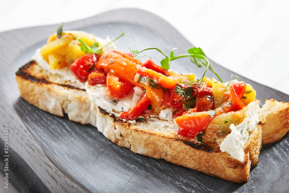 Delicious bruschetta with baked peppers close up view