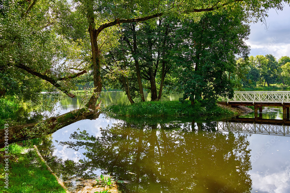 Wooden bridge on the lake. Bridge to the island in the summer. Wooden bridge on the lake. Bridge to the island in the summer.