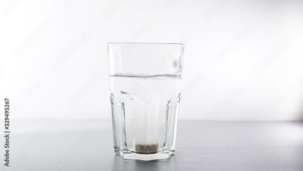 a pill from coronavirus falls into a glass and begins to dissolve with a hiss, slow mo a pill from coronavirus falls into a glass and begins to dissolve with a hiss, slow mo