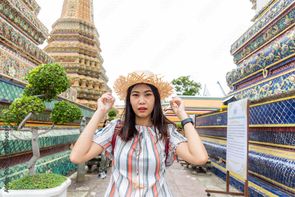 Beautiful asian tourist backpack women walking travel in buddhistm temple pagoda statue