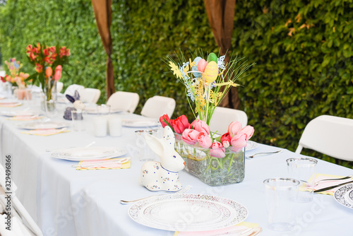 table holiday serving decoration on a patio easter idea with flower bouquet easter eggs rabbit with blue table cloth