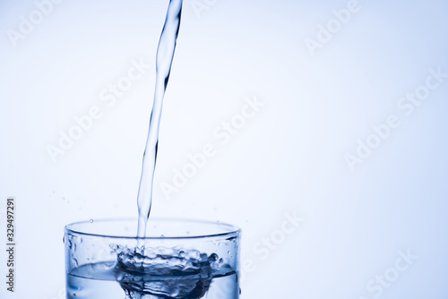 Drinking clean water concept. Cropped closeup photo picture of top of glass fresh pure tasty mineral water isolated over light blue white background