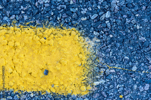 Extreme close up of a yellow line on an asphalt road