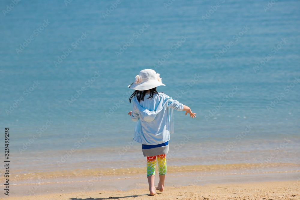 海の砂浜で遊んでいる可愛い子供