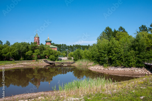 Russian village, summer landscape lake and old Orthodox Church