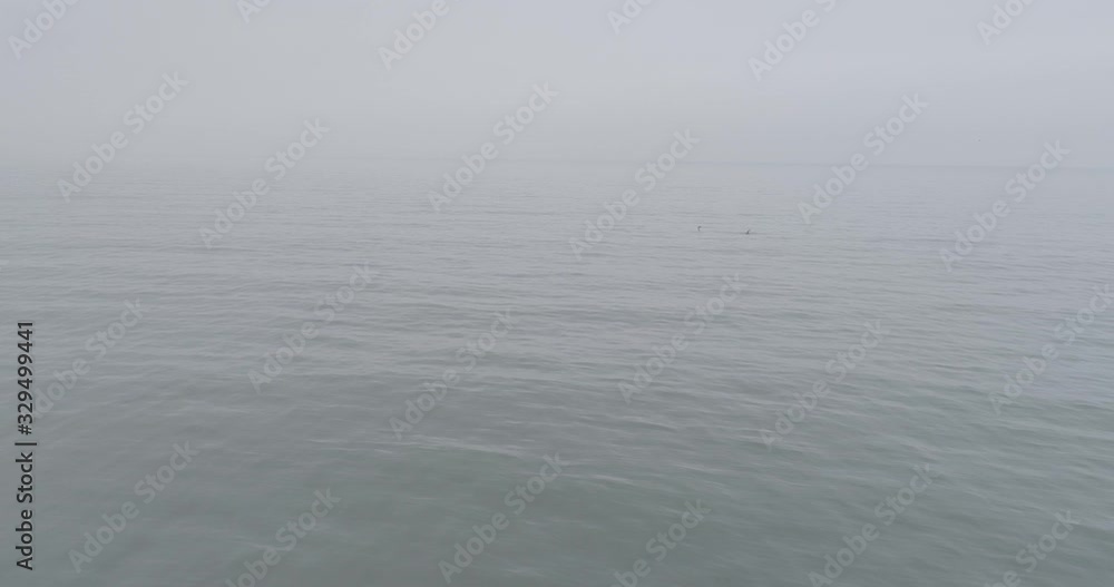 It takes aerial, the movement is backwards, from the sea, looking at the horizon towards the beach, crossing rocks and sand. It takes aerial, the movement is backwards, from the sea, looking at the horizon towards the beach, crossing rocks and sand.
