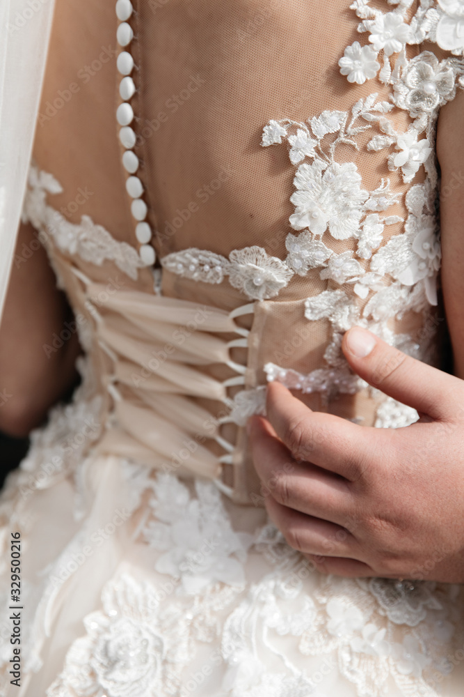 back of a girl in a white dress in the arms of a male hand back of a girl in a white dress in the arms of a male hand