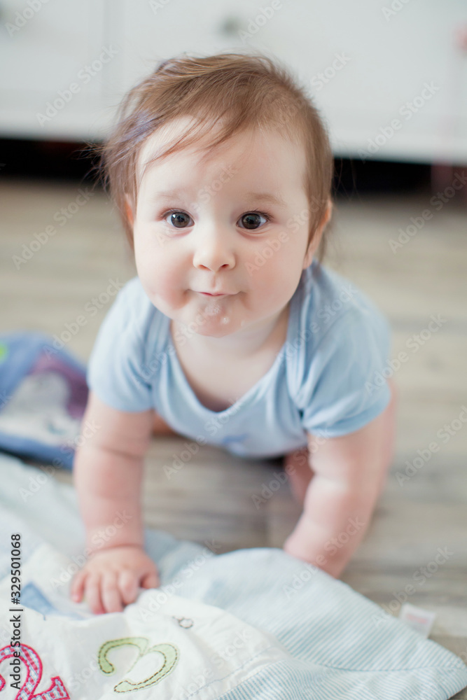 Fototapeta premium Cute caucasian baby in a blue cloth