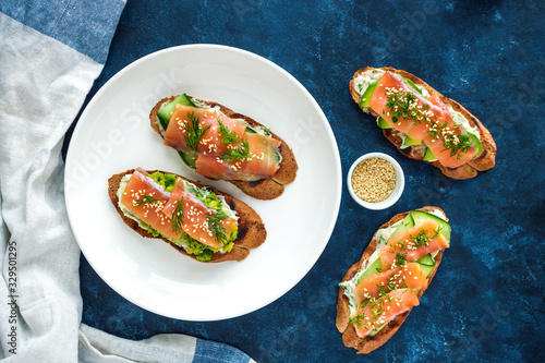homemade  healthy open sandwiches with salmon avocado cucumber  cream cheese dill on plate top view
