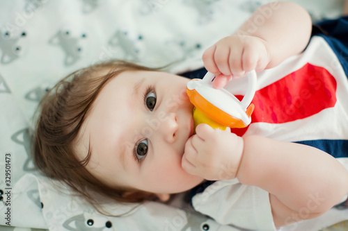 Little boy eat fruits from baby's nibbler photo