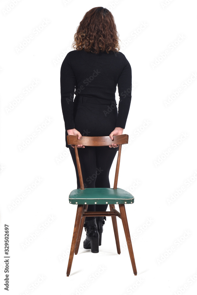 Fototapeta premium rear view of woman standing on a chair in white background