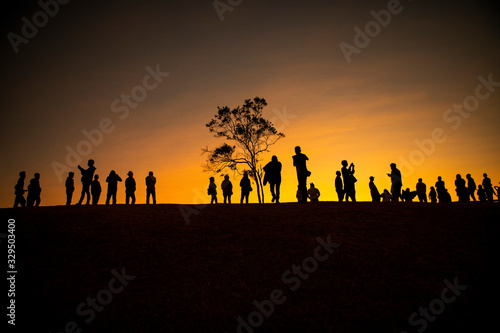 large number of people standing on hill top against beautiful sun rising sky