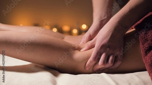 Wallpaper Mural Close-up of premium anti-cellulite thigh massage. Male hands do wellness massage of the thigh to the patient girl in a cozy study with dim light. Luxury massage services Torontodigital.ca