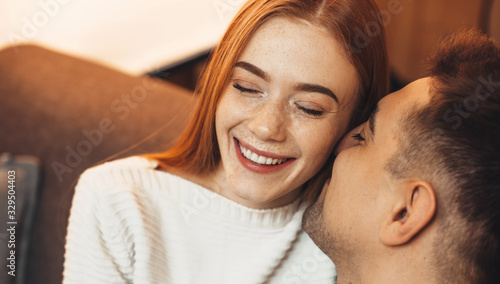 Fotografija Ginger caucasian lady with freckles is cheering with her love while embracing on