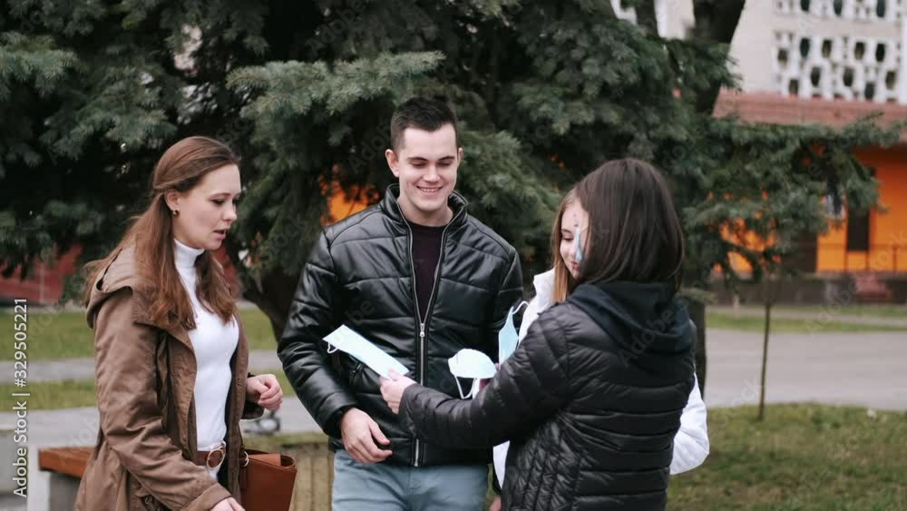Young people are spreading disposable masks. The man and women are discussing virus problem and sharing respirators. Young people are spreading disposable masks. The man and women are discussing virus problem and sharing respirators.