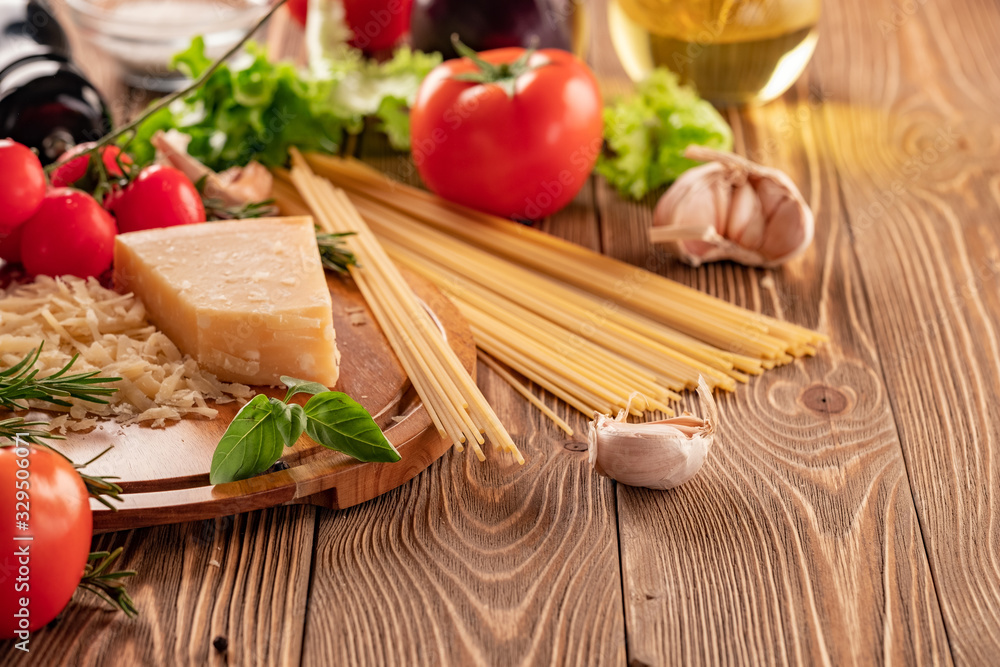 Ingredients for spaghetti bolognese with cherry tomatoes and basil on a wooden table Ingredients for spaghetti bolognese with cherry tomatoes and basil on a wooden table