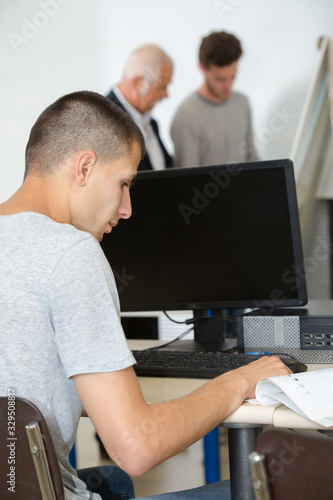 young man doing task and writing on laptop