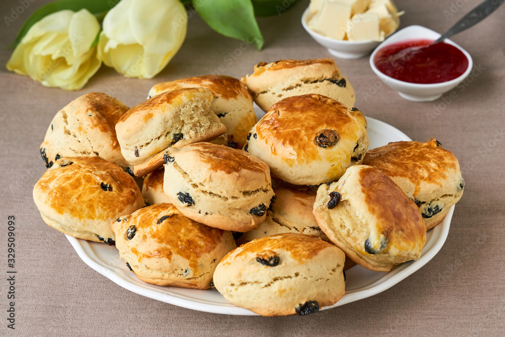English scones with raisins on a white plate English scones with raisins on a white plate