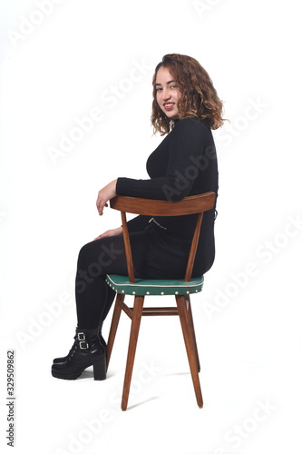 portrait of a woman sitting on a chair in white background,looking at camera photo