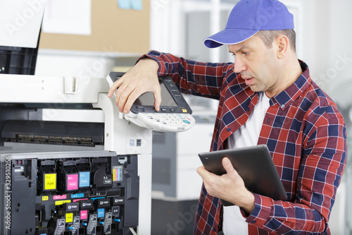 middle age man fixing a printer