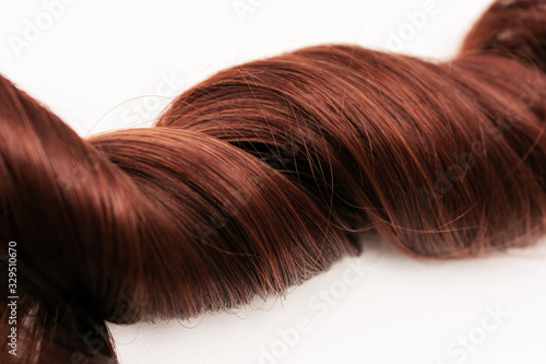 Strand of curly hair  brown hair  closeup  white background