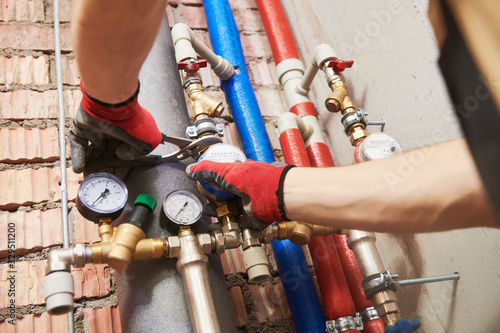 фотографія plumber installing water equipment - meter, filter and pressure reducer