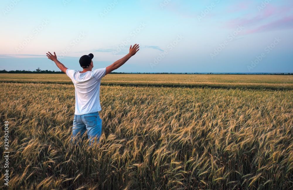 Male farmer standing in a wheat field during sunset. Man Enjoys Nature Male farmer standing in a wheat field during sunset. Man Enjoys Nature