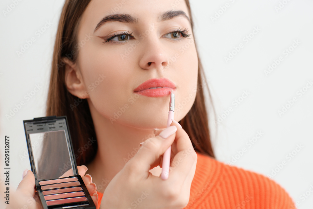 Professional makeup artist working with young woman in salon, closeup Professional makeup artist working with young woman in salon, closeup