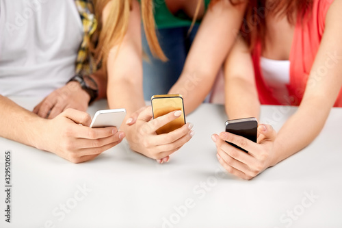 technology and people concept - close up of hands with smartphones