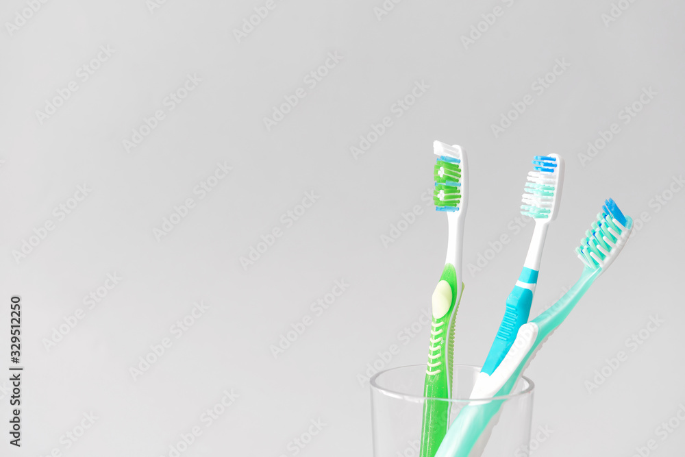 Tooth brushes in glass on light background Tooth brushes in glass on light background