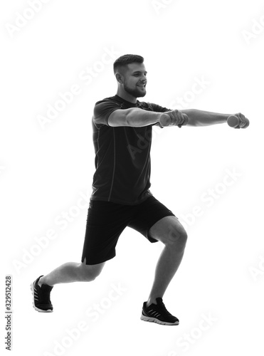 Silhouette of sporty young man training on white background