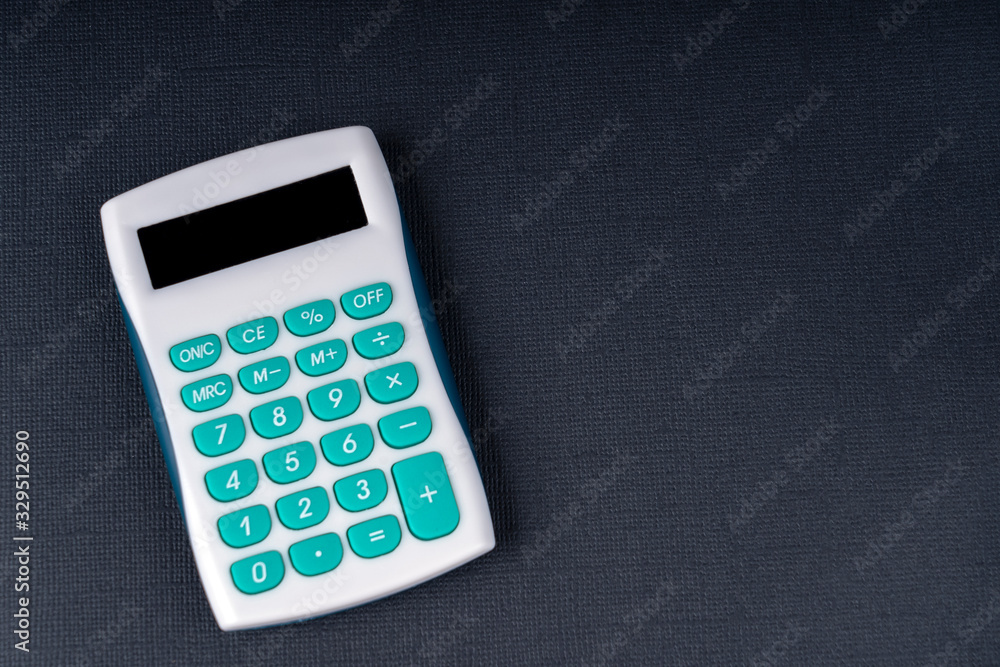 Modern calculator, business and Finance accounting concept on a black textural background, space for text on the right Modern calculator, business and Finance accounting concept on a black textural background, space for text on the right