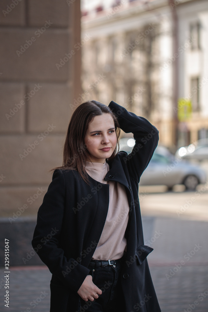 young woman in casual style on a city street. Portrait of a beautiful stylish woman. vertical photo young woman in casual style on a city street. Portrait of a beautiful stylish woman. vertical photo