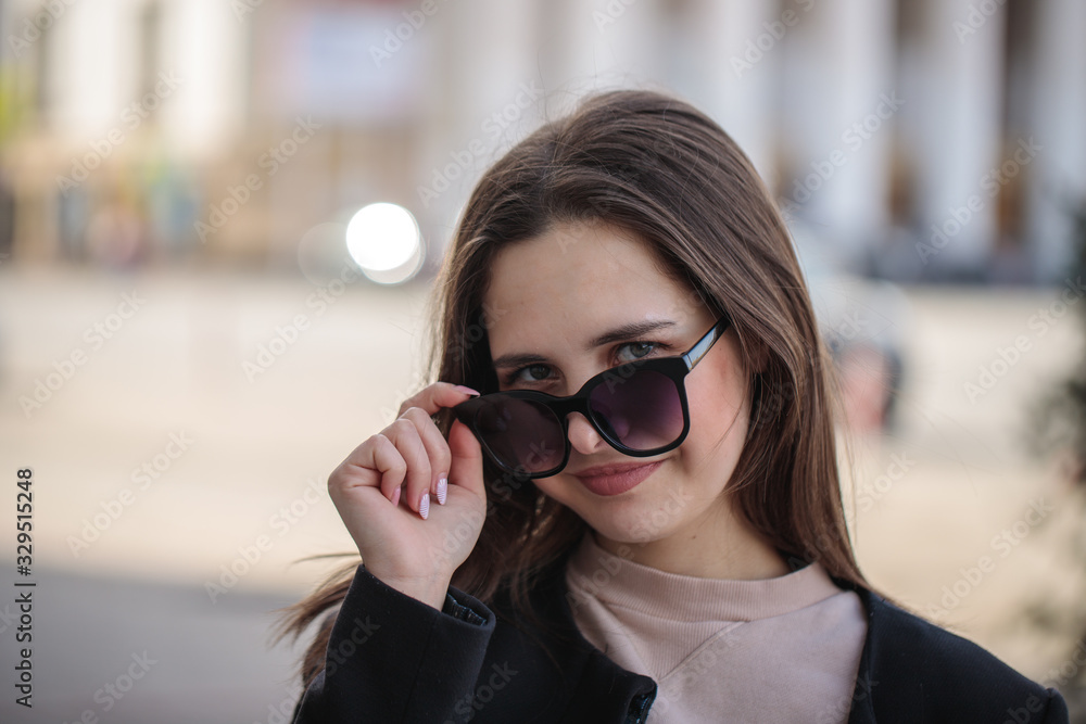 young woman in sunglasses on the city streets. Portrait of a beautiful stylish woman. close-up young woman in sunglasses on the city streets. Portrait of a beautiful stylish woman. close-up