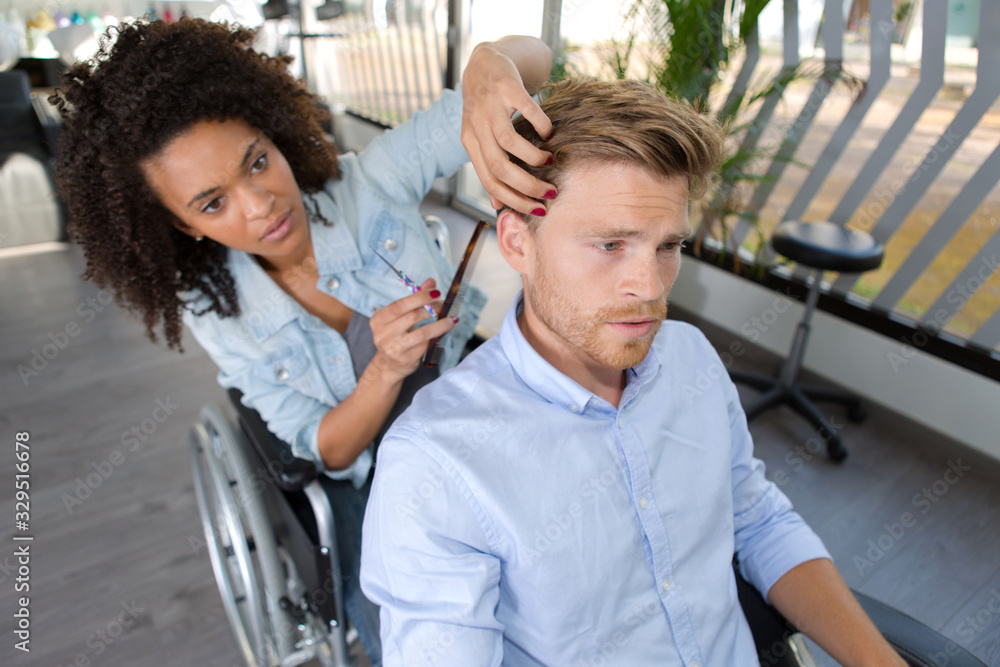 Obraz premium a professional hairdresser in wheelchair