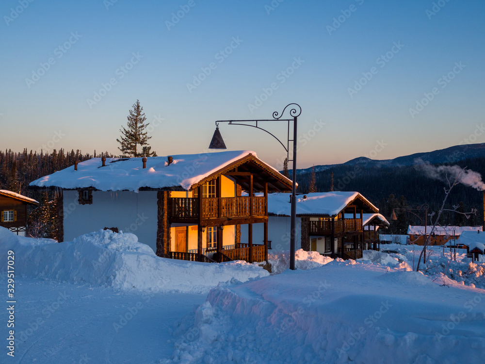 Alpine village in the ski resort Gornaya Salanga. The sun rises. Beautiful morning lighting