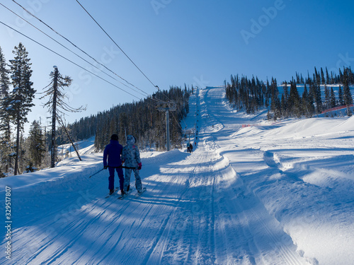 Skiers climb the mountain on a special ski lift. Winter sunny day at the resort